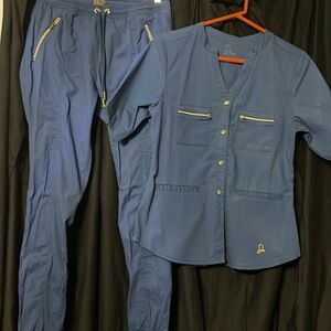 Jaanuu scrubs top and bottom, navy blue and gold accents, size S on both